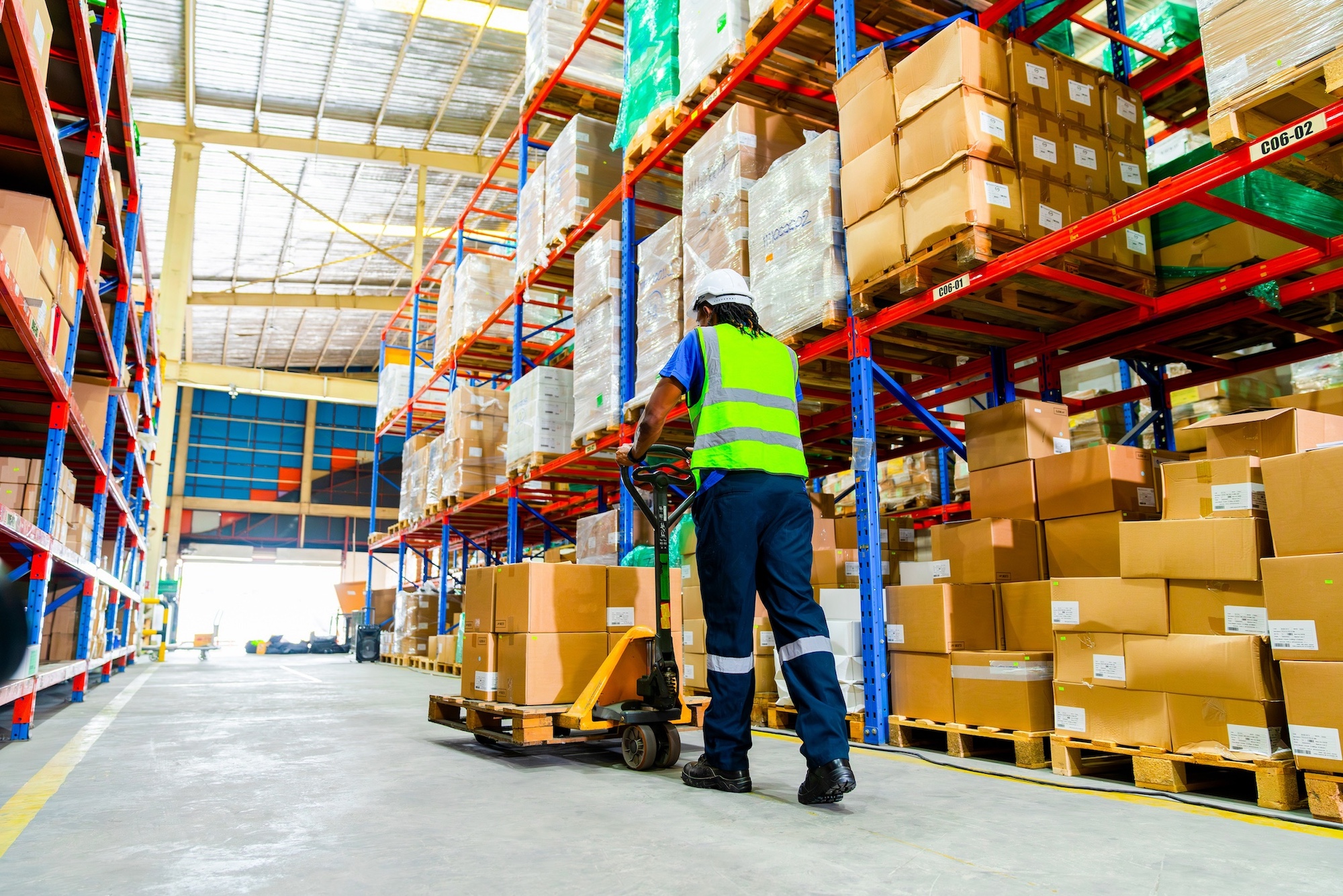 Warehouse worker with pallet jack Warehouse worker with pallet jack carrying boxes